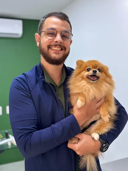 Veterinário da Clínica Bixo's abraçando um lulu da pomerânia