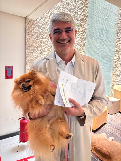 Veterinário da Clínica Bixo's sorrindo com um lulu da pomerânia no colo